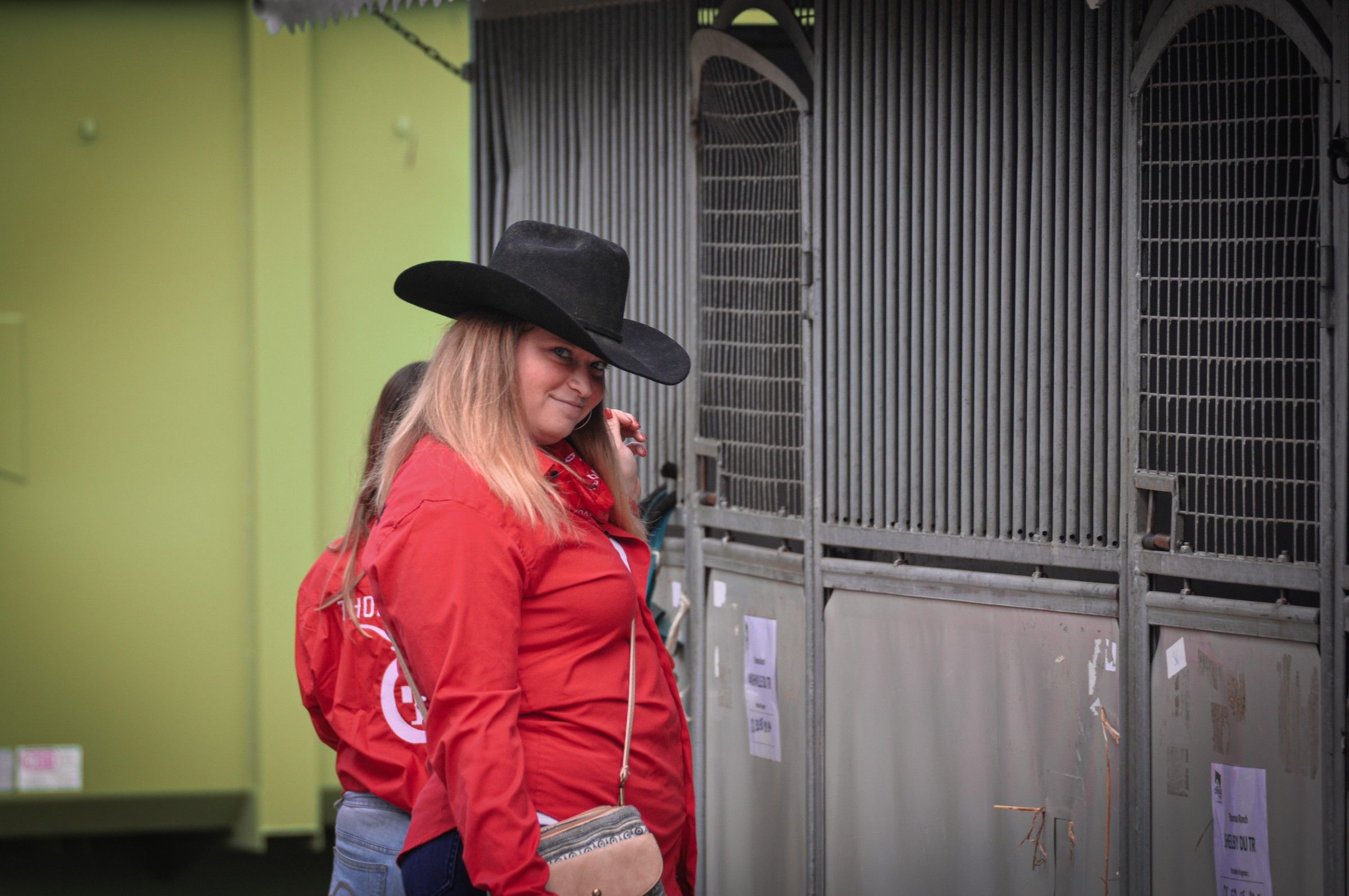 Deux cavalières en chemises rouges Thomas’ Ranch devant des boxes, au salon