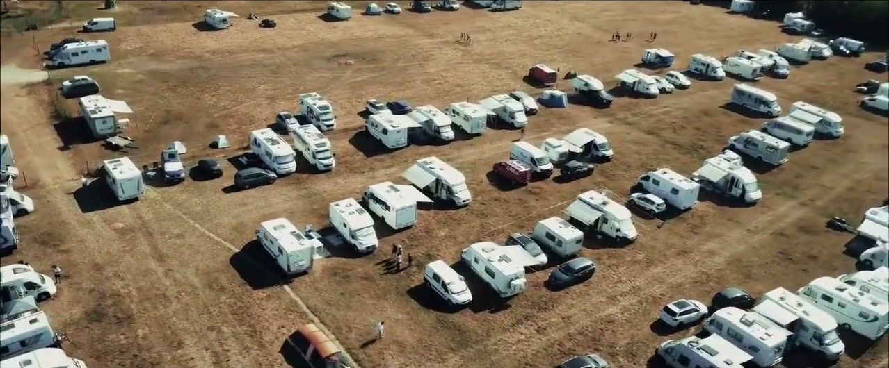 Terrain de camping du festival rempli de camping-cars, vu du ciel