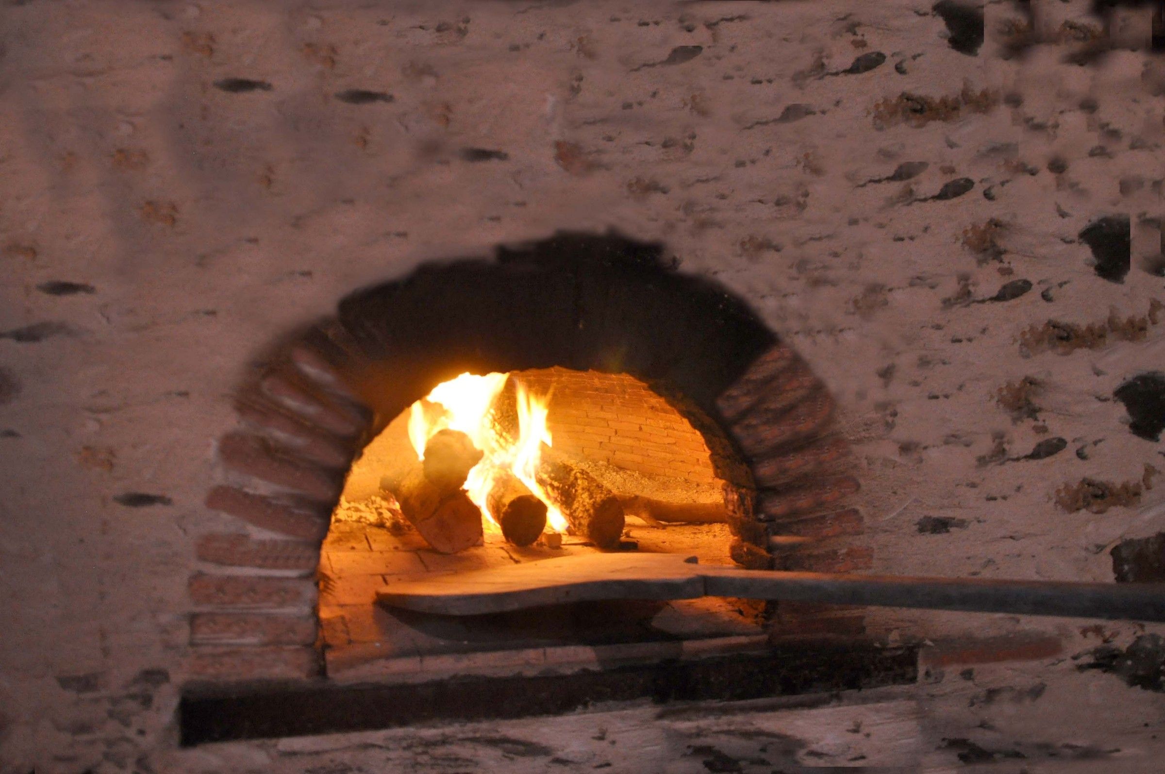 Le four à pain de la Thom’House allumé, flammes sous la voûte en brique
