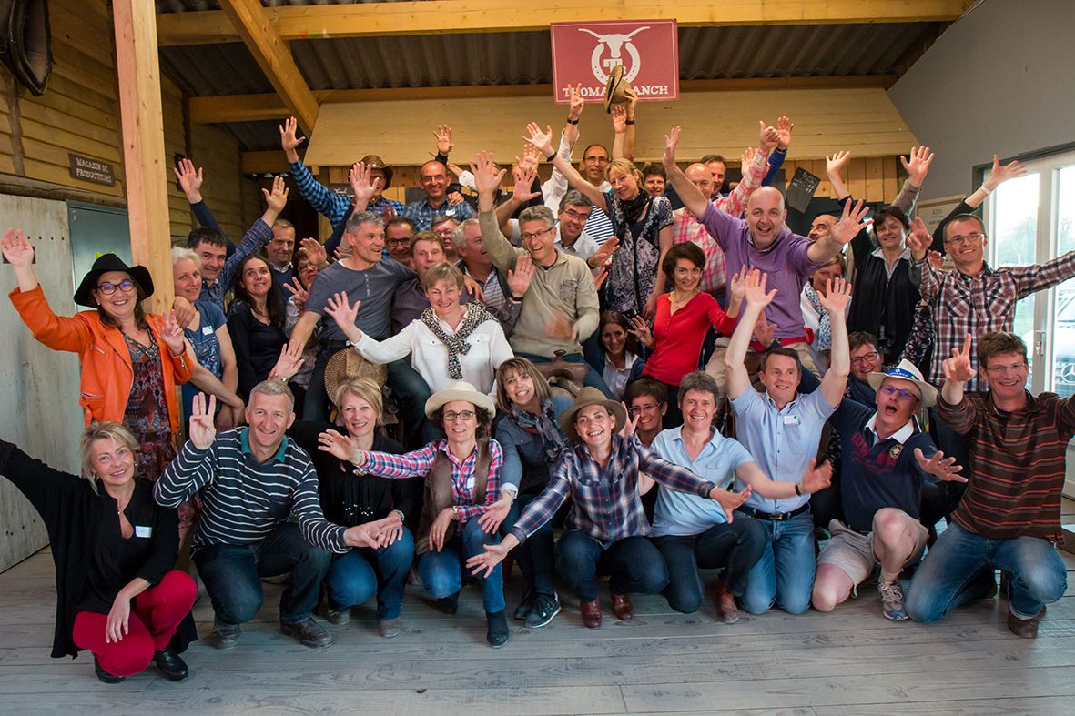 Groupe de séminaire bras levés sous le hangar du ranch