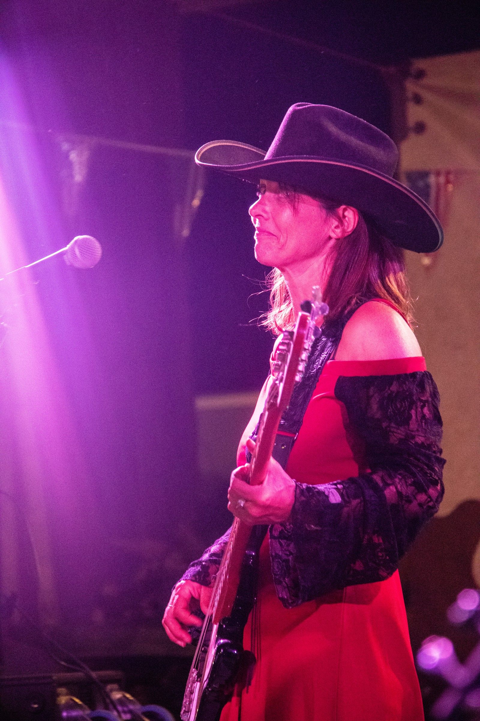 Stéphanie Thomas à la guitare sur scène avec Les Ranchers, robe rouge et chapeau de cow-boy