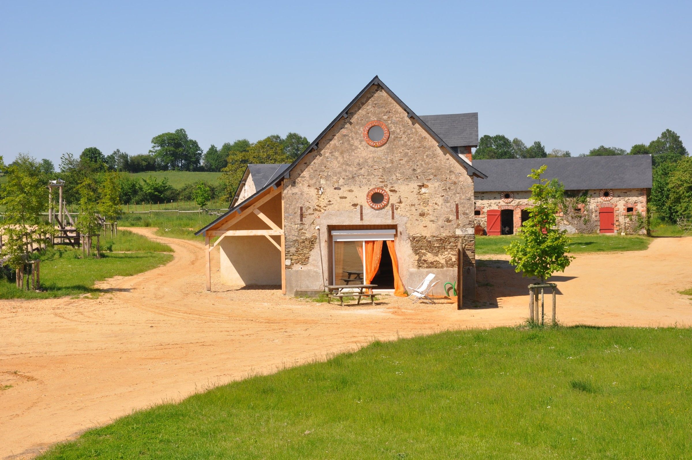 The Little Ranch, a stone house beside a sandy track