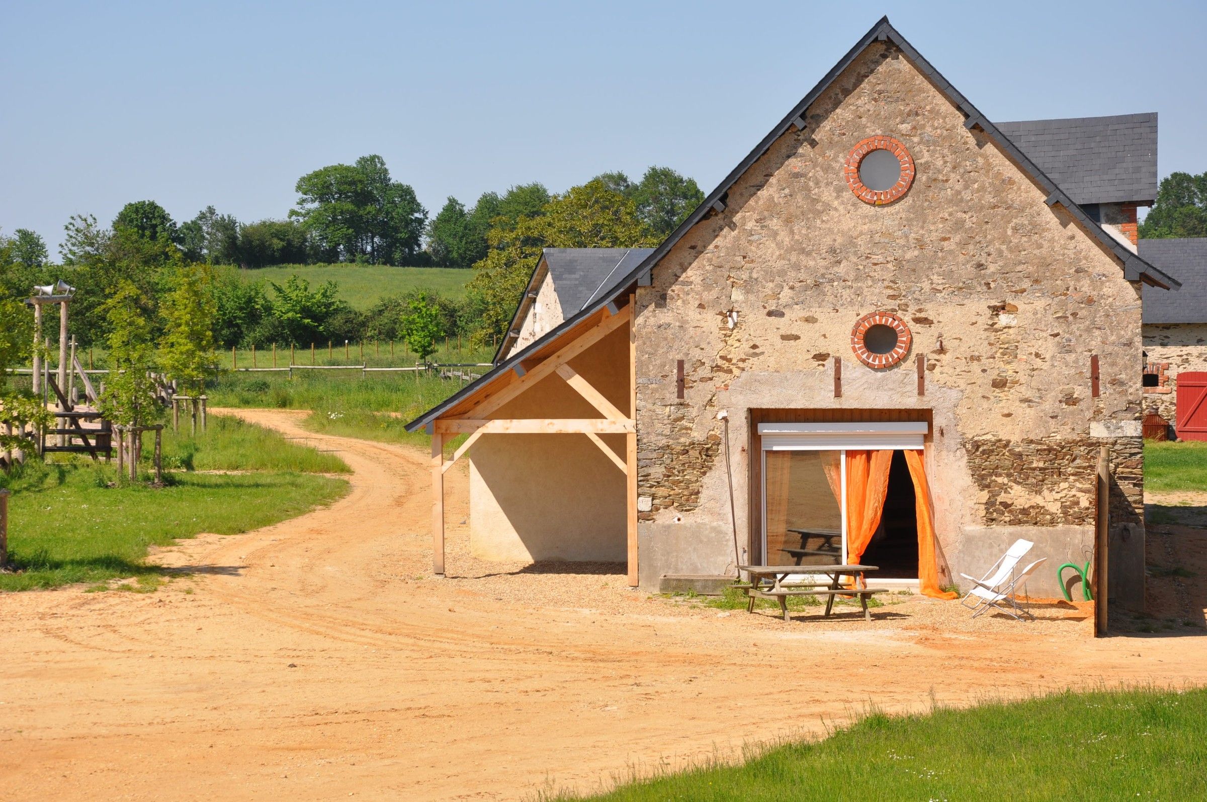 Le Little Ranch, gîte en pierre du ranch, au bout d’un chemin de sable bordé de pré