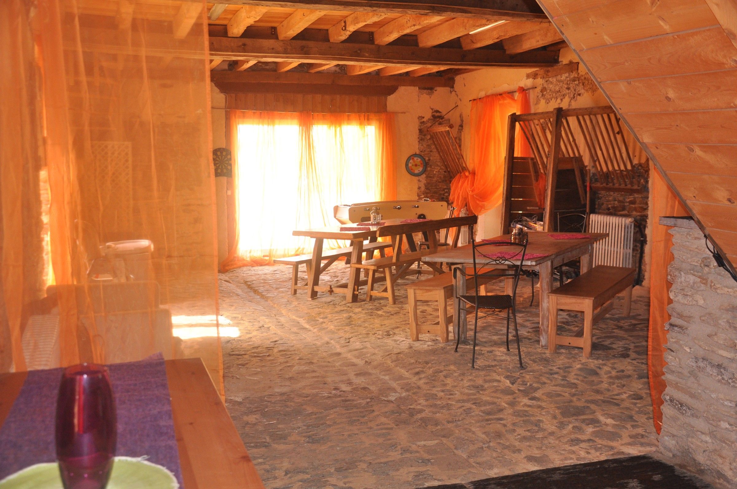 La pièce de vie du Little Ranch, voilages orange et lumière du jour