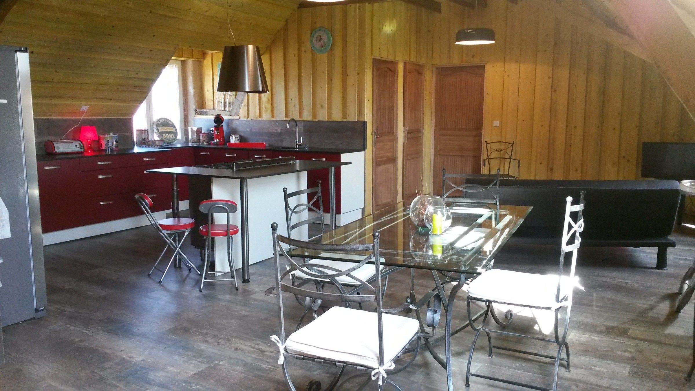 La cuisine ouverte et la table du Loft, murs en bois