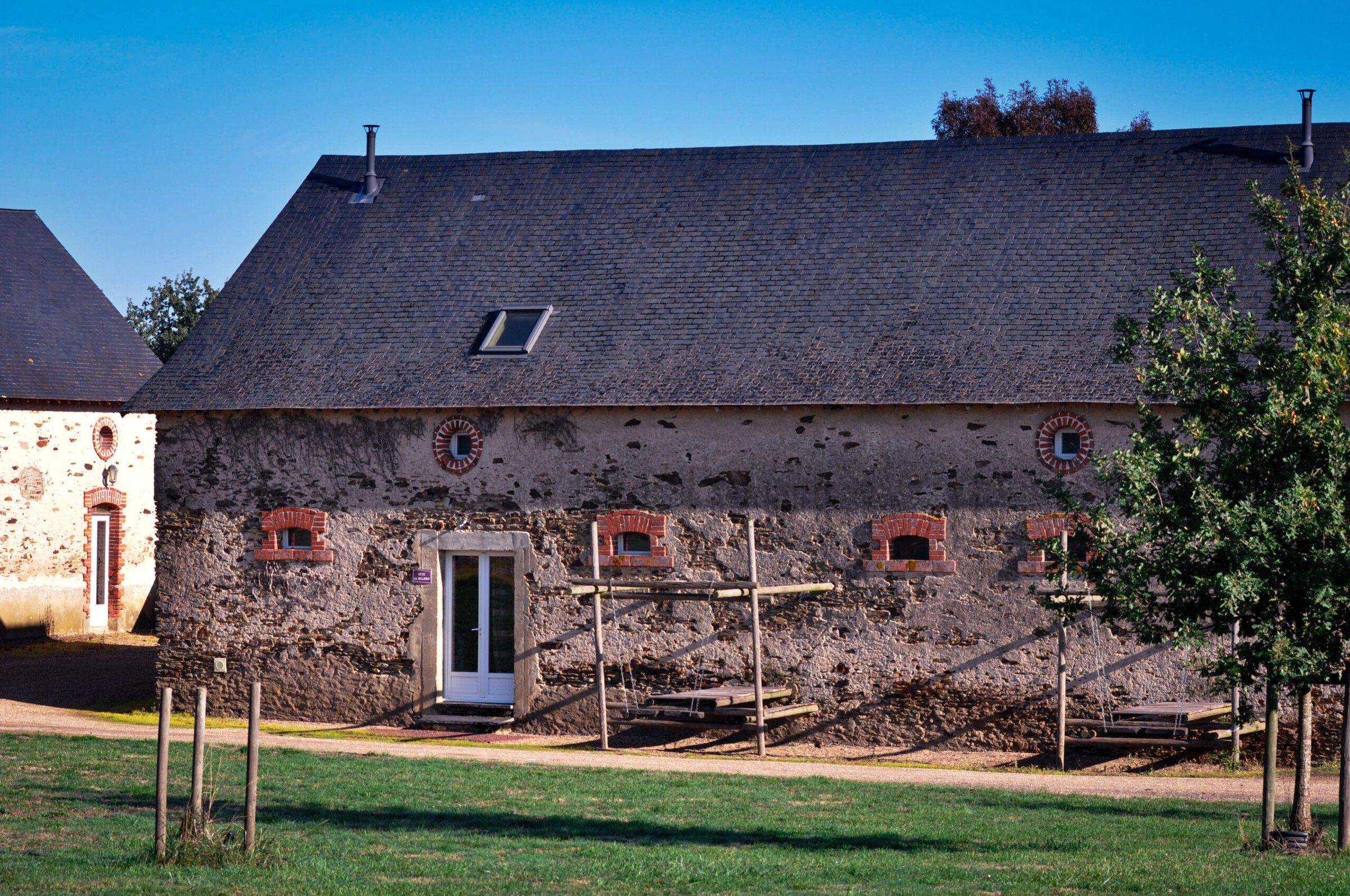 La Sellerie, a long stone farmhouse under a blue sky